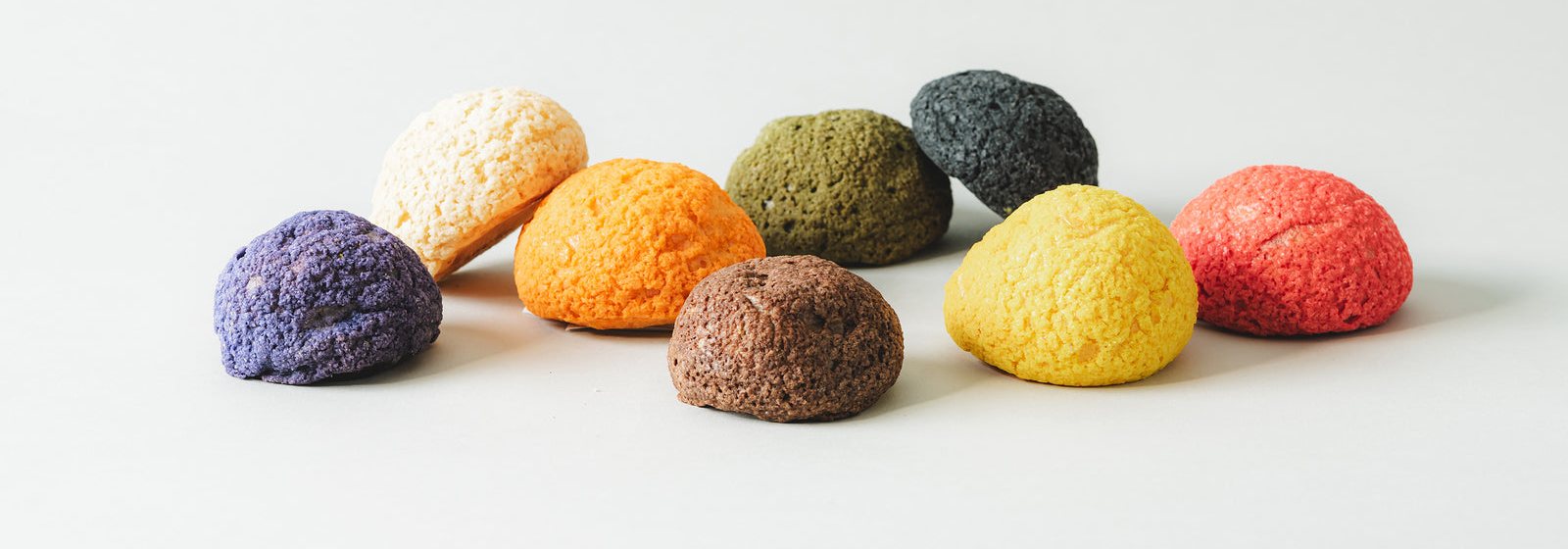 カラフルなクッキーシューが並ぶ。白・オレンジ・紫・抹茶・黒・茶・黄・赤